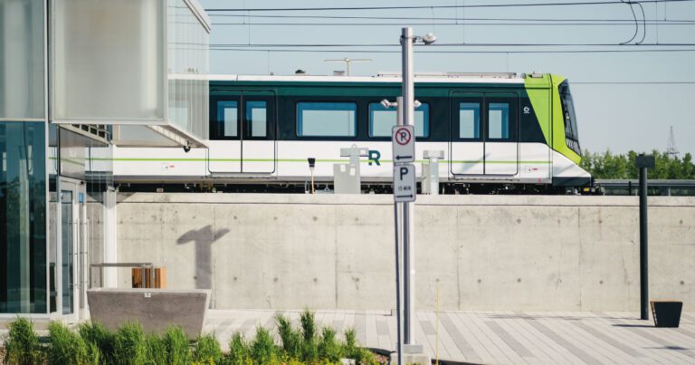 Train du REM à quai, vu depuis une station moderne aux lignes épurées.