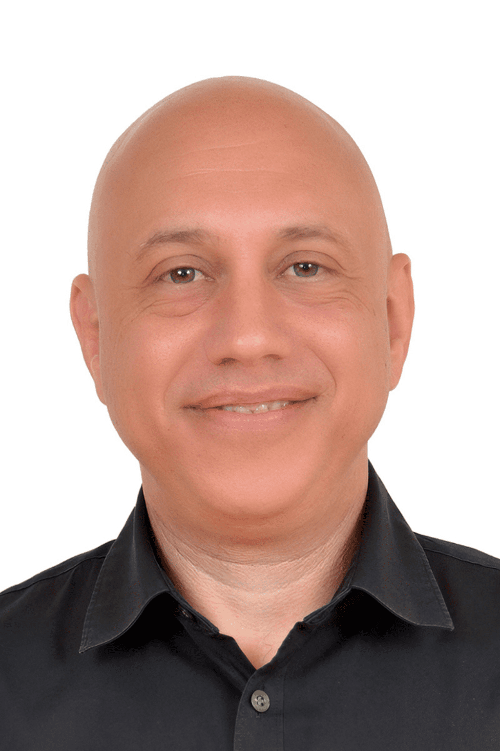 Portrait professionnel de Karim-André Laz, homme souriant au crâne rasé, portant une chemise noire, sur fond blanc.