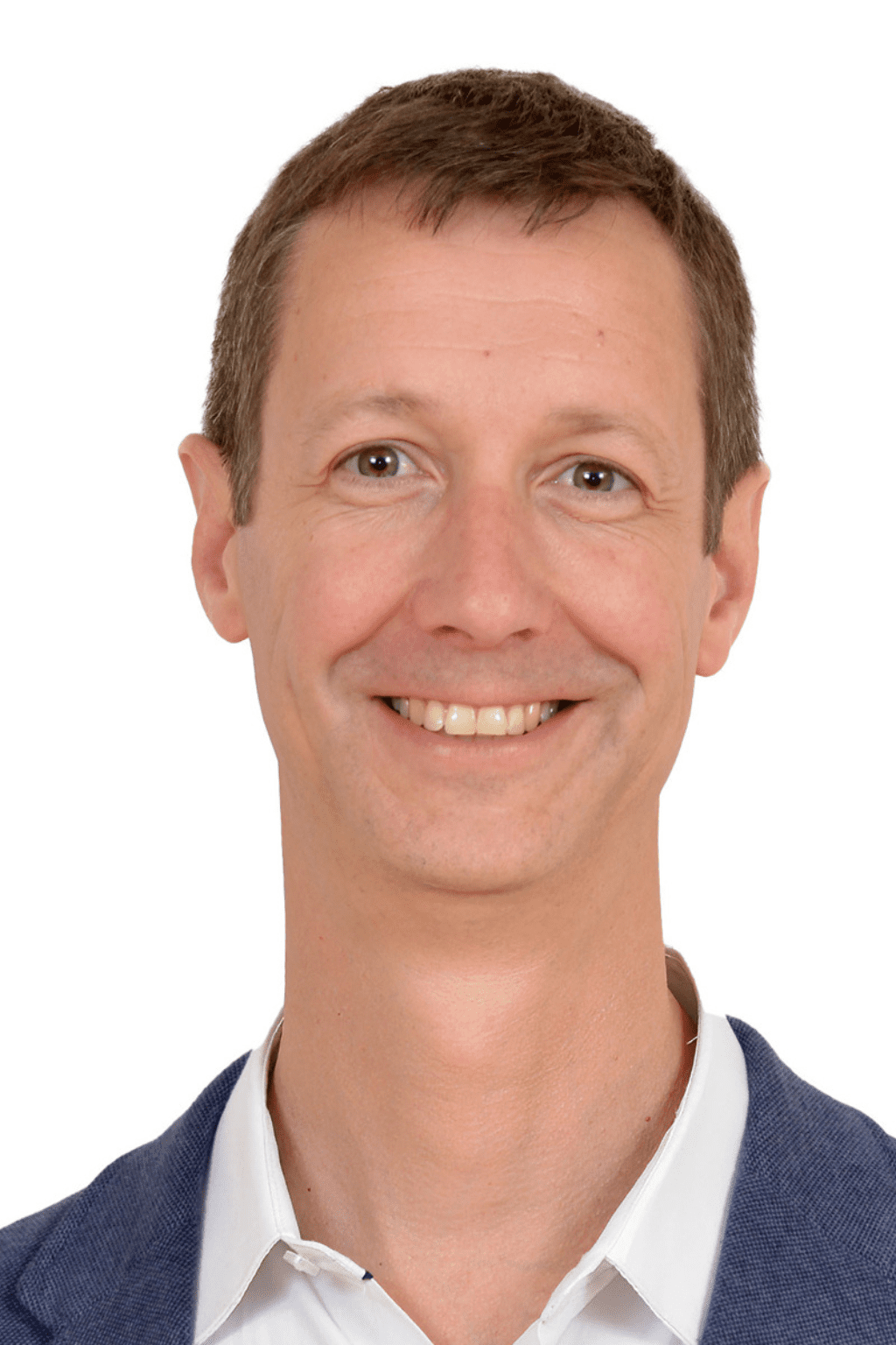 Portrait professionnel de Jérôme Dognin, homme souriant aux cheveux courts châtains, portant une chemise blanche et un veston bleu, sur fond blanc.