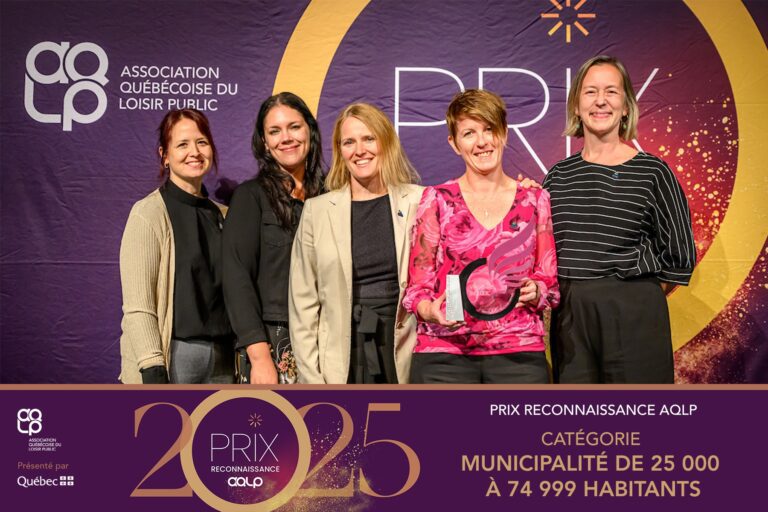 Photo de groupe de cinq femmes souriantes posant devant une bannière de l’Association québécoise du loisir public (AQLP) lors du Prix reconnaissance 2025.