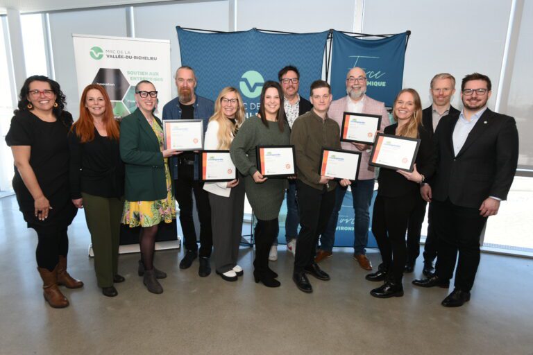 Photo de groupe de 12 personnes lors d’une remise de reconnaissances entrepreneuriales organisée par la MRC de la Vallée-du-Richelieu; plusieurs participants tiennent un certificat devant des bannières de l’événement.