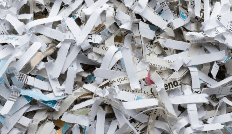 Papier déchiqueté composé de bandes blanches et imprimées entremêlées.