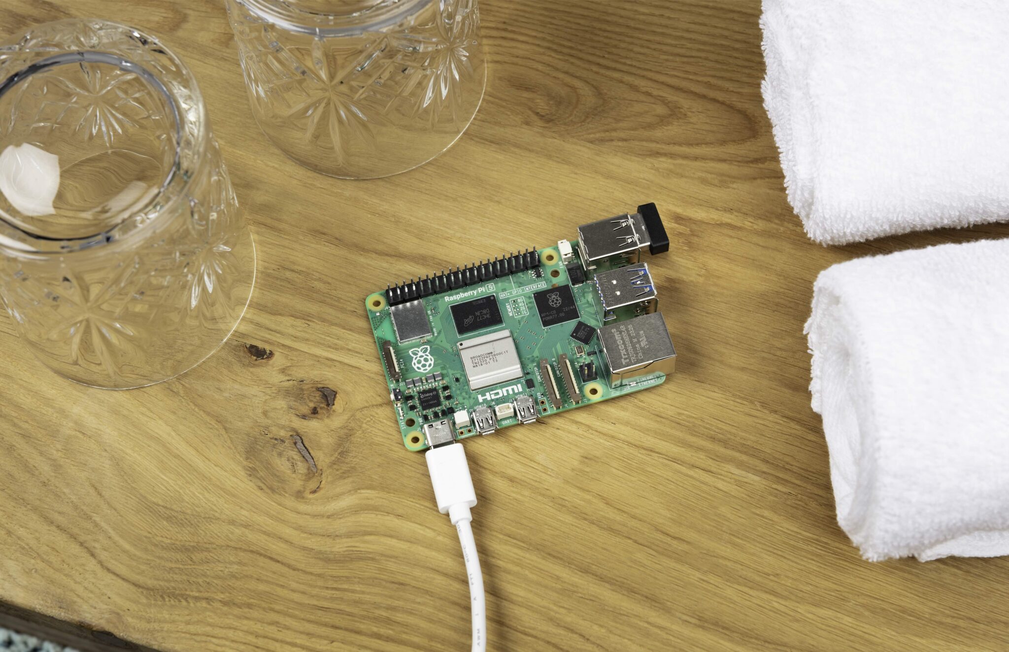 Micro-ordinateur Raspberry Pi branché par câble USB sur une table en bois.